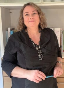 Frau steht vor Bücherregal